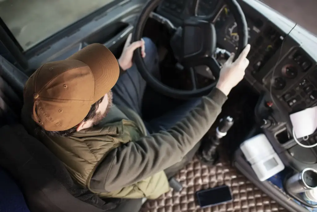 Chauffeur en train de conduire un camion, vue de haut dans sa cabine